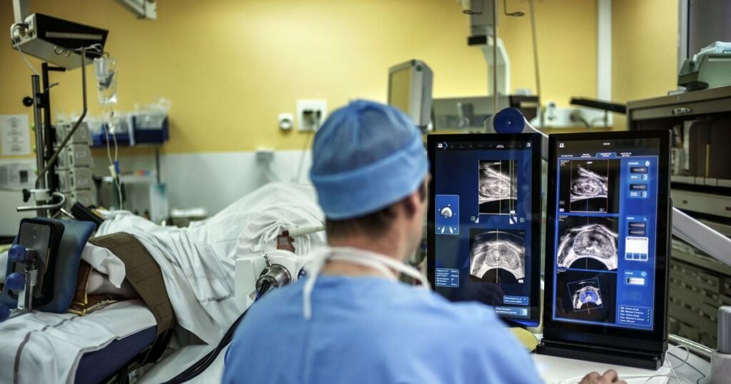 A surgeon sitting in front of screens of a Focal One device performs a robot-assisted prostate tumorectomy using ultrasound imaging on April 10, 2014 at the Edouard Herriot hospital in Lyon, center France. Focal One is the first robotic HIFU (high intensity focused ultrasound) device dedicated to the focal approach for prostate cancer therapy. According to EDAP TMS SA, a leader in therapeutic ultrasound, it combines the three essential components to efficiently perform a focal treatment: state-of-the-art imaging to localized tumors with the use of magnetic resonance imaging (MRI) combined with real-time ultrasound, utmost precision of robotic HIFU treatment focused only on identified targeted cancer areas, and immediate feedback on treatment efficacy utilizing Contrast-Enhanced Ultrasound Imaging. AFP PHOTO / JEFF PACHOUD (Photo by JEFF PACHOUD / AFP)