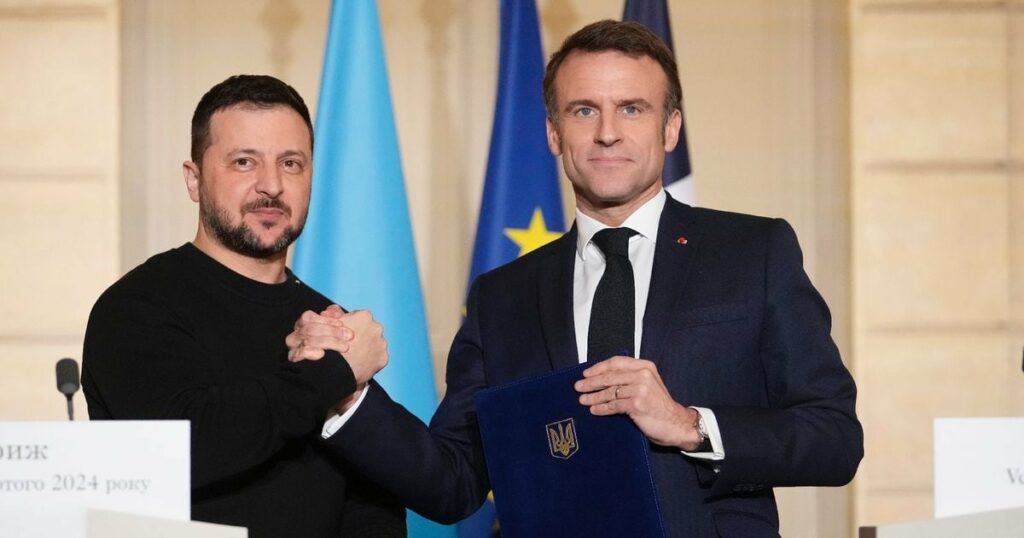 Le président français Emmanuel Macron (droite) et son homologue ukrainien Volodymyr Zelensky se serrent la main, le 16 février 2024 à Paris