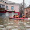 Emergency workers ride a boat to evacuate Russians trapped by flooding. Pic: AP