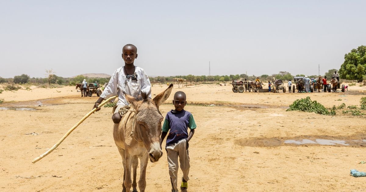 Deux jeunes traversent la frontière entre le Tchad et le Soudan dans le camp de réfugiés de Koufroun, le 9 avril 2024