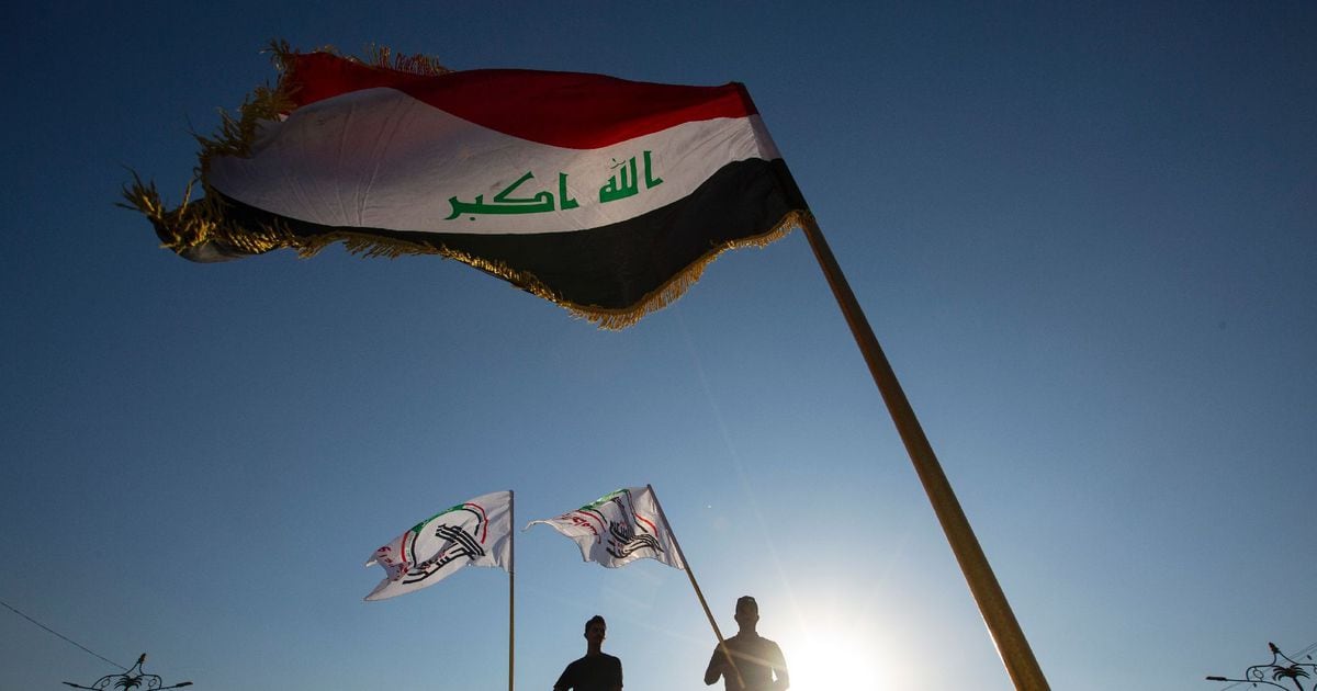 Photo prise le 17 octobre 2020 de partisans du Hachd al-Chaabi, paramilitaires pro-Iran intégrés à l'Etat irakien, brandissant le drapeau du Hachd à Basra, dans le sud de l'Irak