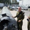 Le porte-parole de l'armée israélienne, le contre-amiral Daniel Hagari (C), et d'autres militaires se tiennent à côté d'un missile balistique iranien tombé en Israël, lors d'une tournée à la base de Julis dans le sud d'Israël, le 16 avril 2024