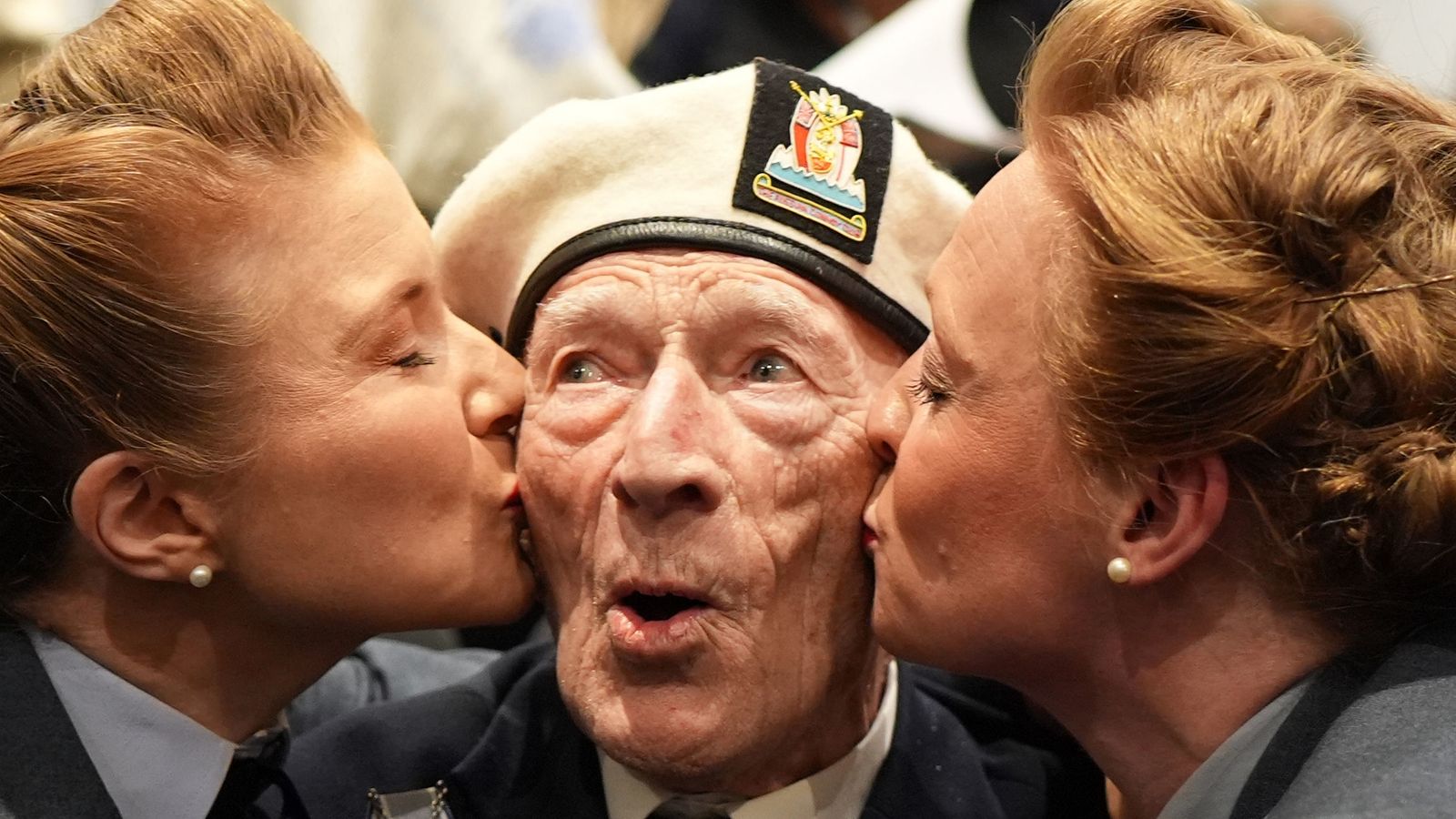 D-Day veteran Alec Penstone, 98, who served with the Royal Navy, receives a kiss from the D-Day Darlings. Pic: PA