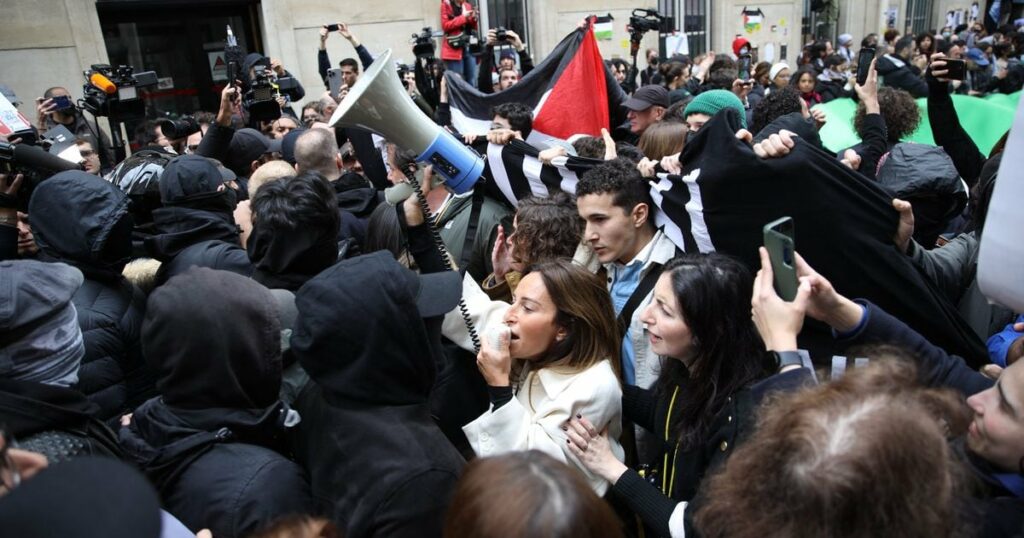 Des contre-manifestants, tenant des pancartes du collectif "Nous Vivrons" en soutien à Israël font face à des manifestants en soutien aux Palestiniens manifestant à l'entrée de Sciences Po Paris occupé par des étudiants, à Paris le 26 avril 2024.