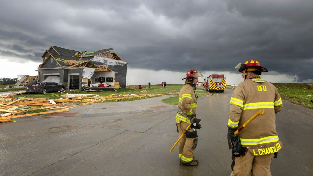 Firefighters assess the damage to houses after a tornado passed through the area near Omaha, Neb., on Friday, April 26, 2024. (Chris Machian/Omaha World-Herald via AP)