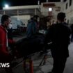 A person being wheeled into hospital on a gurney by hospital workers