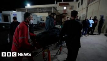 A person being wheeled into hospital on a gurney by hospital workers