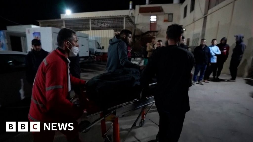 A person being wheeled into hospital on a gurney by hospital workers