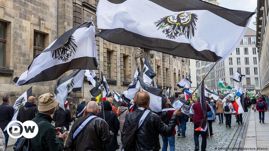 A 75-year-old woman, part of the so-called "United Patriots" terror group, appears in court accompanied by armed police in the Germany city of Koblenz.