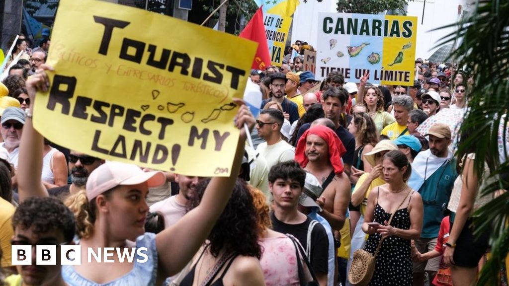 Protesters in Santa Cruz de Tenerife hold placards against mass tourism in Spain's Canary Islands. Photo: 20 April 2024