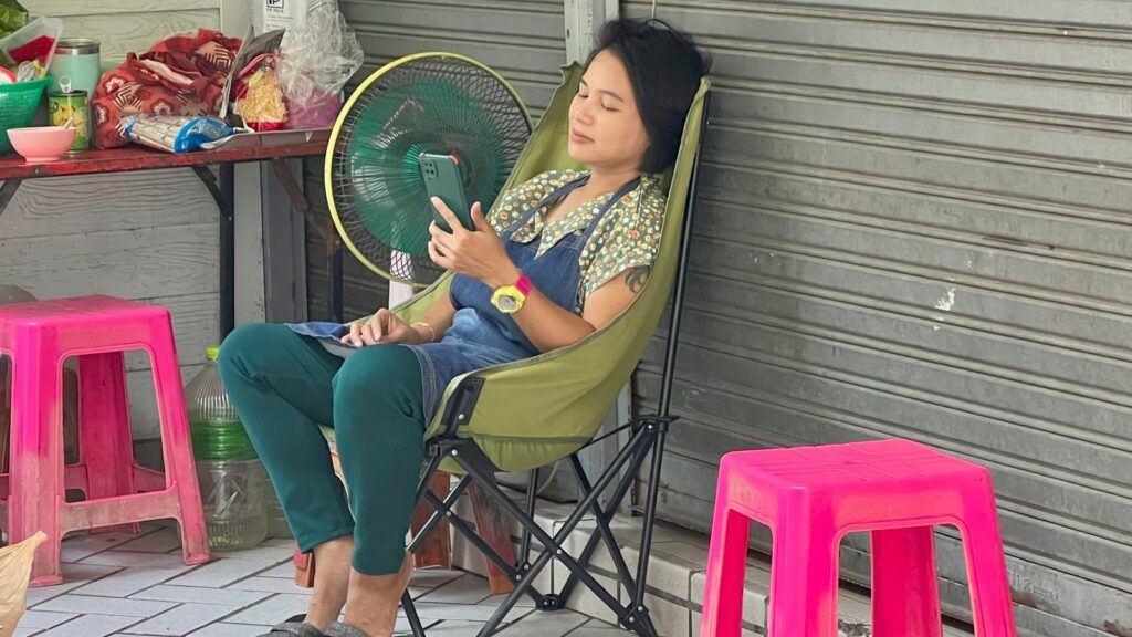 A woman cools off by a fan in Thailand. Pic: AP