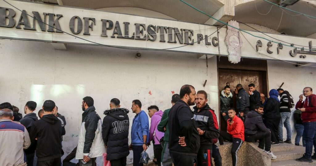 GAZA CITY, GAZA - 8 DECEMBRE : Les Palestiniens font la queue devant le guichet automatique de la Banque de Palestine pour retirer de l'argent après que le gouvernement a déposé les salaires de la population pour une courte période depuis le 7 octobre, dans la ville de Gaza, Gaza le 8 décembre 2023. Abed Rahim Khatib / Anadolu (Photo by Abed Rahim Khatib / ANADOLU / Anadolu via AFP)