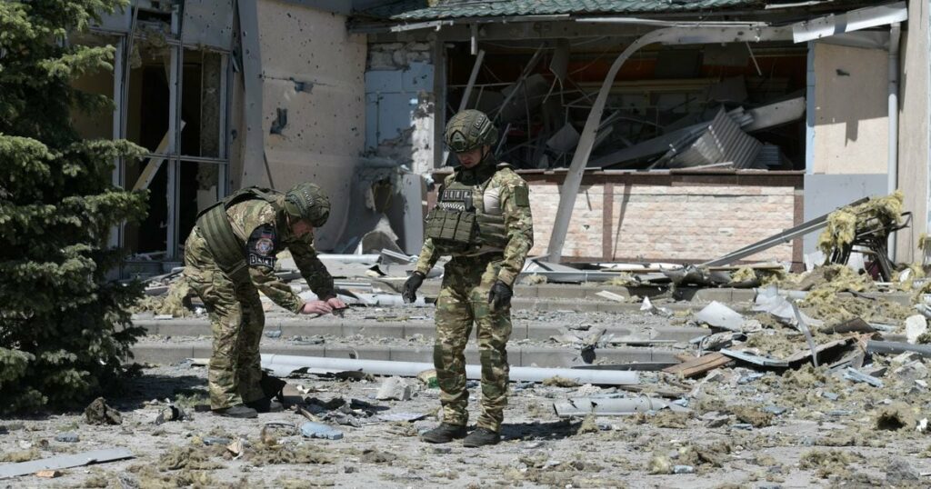 Des enquêteurs militaires travaillent sur le site du bâtiment endommagé abritant le restaurant Paradise à la suite d'une frappe à Donetsk, en Ukraine contrôlée par la Russie, le 11 mai 2024, dans le cadre du conflit russo-ukrainien en cours. (Photo STRINGER / AFP)