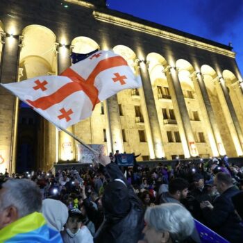 Un manifestant brandit le drapeau de la Géorgie lors d'un rassemblement contre le projet de loi controversé sur "l'influence étrangère" à Tbilissi le 14 mai 2024.