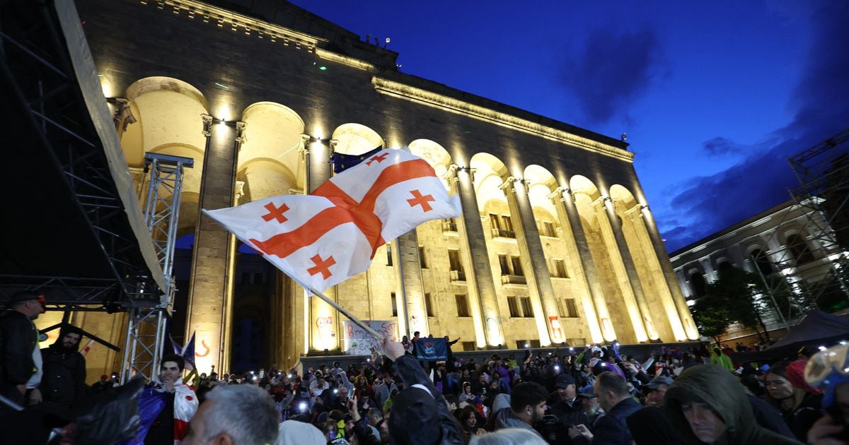 Un manifestant brandit le drapeau de la Géorgie lors d'un rassemblement contre le projet de loi controversé sur "l'influence étrangère" à Tbilissi le 14 mai 2024.