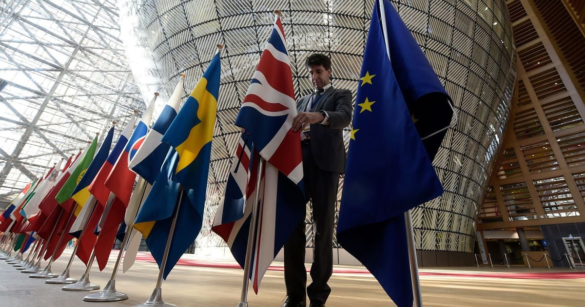 Un homme réajuste le drapeau britannique aux côtés de ceux de l'UE à Bruxelles, le 29 avril 2017