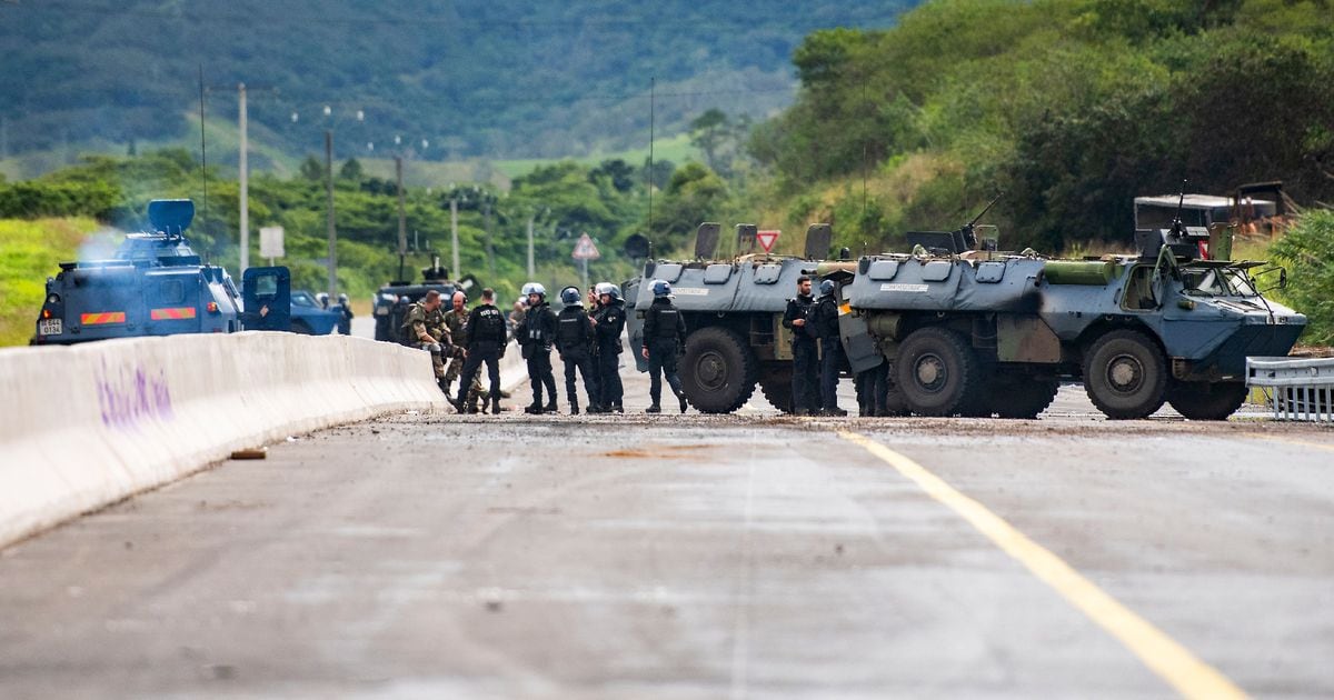 Des gendarmes mobiles sécurisent la zone pendant une opération de nettoyage de la route menant à l'aéroport de Nouméa dans le quartier de Païta, en Nouvelle-Calédonie, le 19 mai 2024