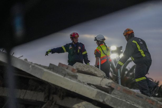 Dozens of people buried in rubble after South African apartment building collapses killing seven