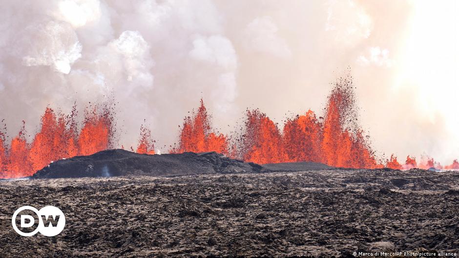 Billowing smoke and flowing lava pouring out of a volcanic fissure