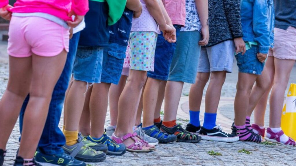 Kinder stehen auf dem Schulhof einer Grundschule. Foto: Jens Büttner/dpa/Symbolbild