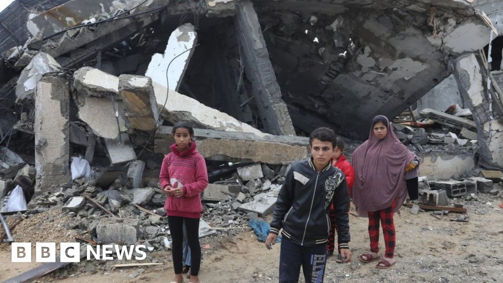 Children outside a destroyed building in Gaza