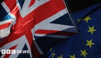 A Union flag, also known as Union Jack, left, and a European Union (EU) flag fly during a Unite for Europe march to protest Brexit in central London, U.K.