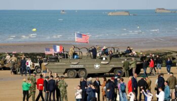Des visiteurs près de camions amphibies DUKW sur la plage d'Arromanches-les-Bains, le 5 juin 2024, dans le cadre des commémorations du "Jour J " marquant le 80e anniversaire du débarquement allié de la Seconde Guerre mondiale en Normandie