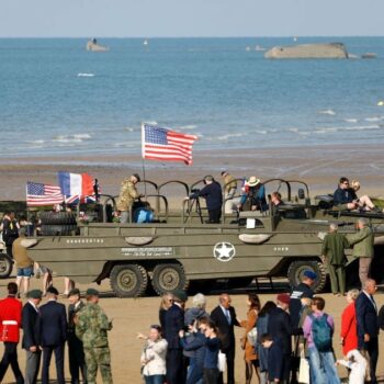 Des visiteurs près de camions amphibies DUKW sur la plage d'Arromanches-les-Bains, le 5 juin 2024, dans le cadre des commémorations du "Jour J " marquant le 80e anniversaire du débarquement allié de la Seconde Guerre mondiale en Normandie