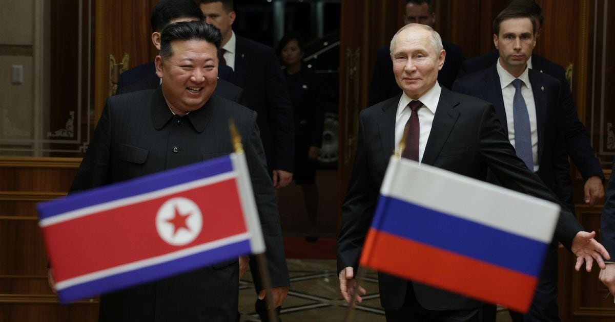 Le dirigeant nord-coréen Kim Jong Un (g) marche avec le président russe Vladimir Poutine lors d'une cérémonie de bienvenue à l'arrivée de ce dernier à Pyongyang, au début du 19 juin 2024