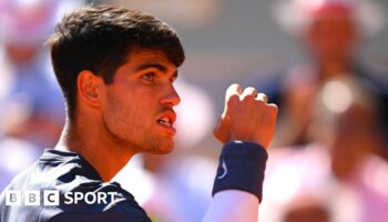 Carlos Alcaraz clenches his fist and his teeth in celebration at the French Open