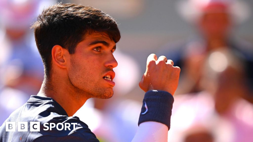 Carlos Alcaraz clenches his fist and his teeth in celebration at the French Open