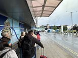 Chaos continues at Birmingham Airport as huge queues in the pouring rain mass as it is claimed wrongly packed baggage is taking 20 minutes each case to clear