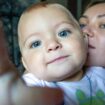 Kinder kriegen: Eine Mutter hält ihr Baby auf dem Arm. Beide schauen in die Kamera