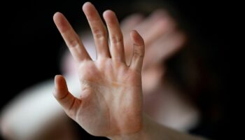 Häusliche Gewalt: Eine nicht erkennbare Frau hält ihre Hände vor das Gesicht