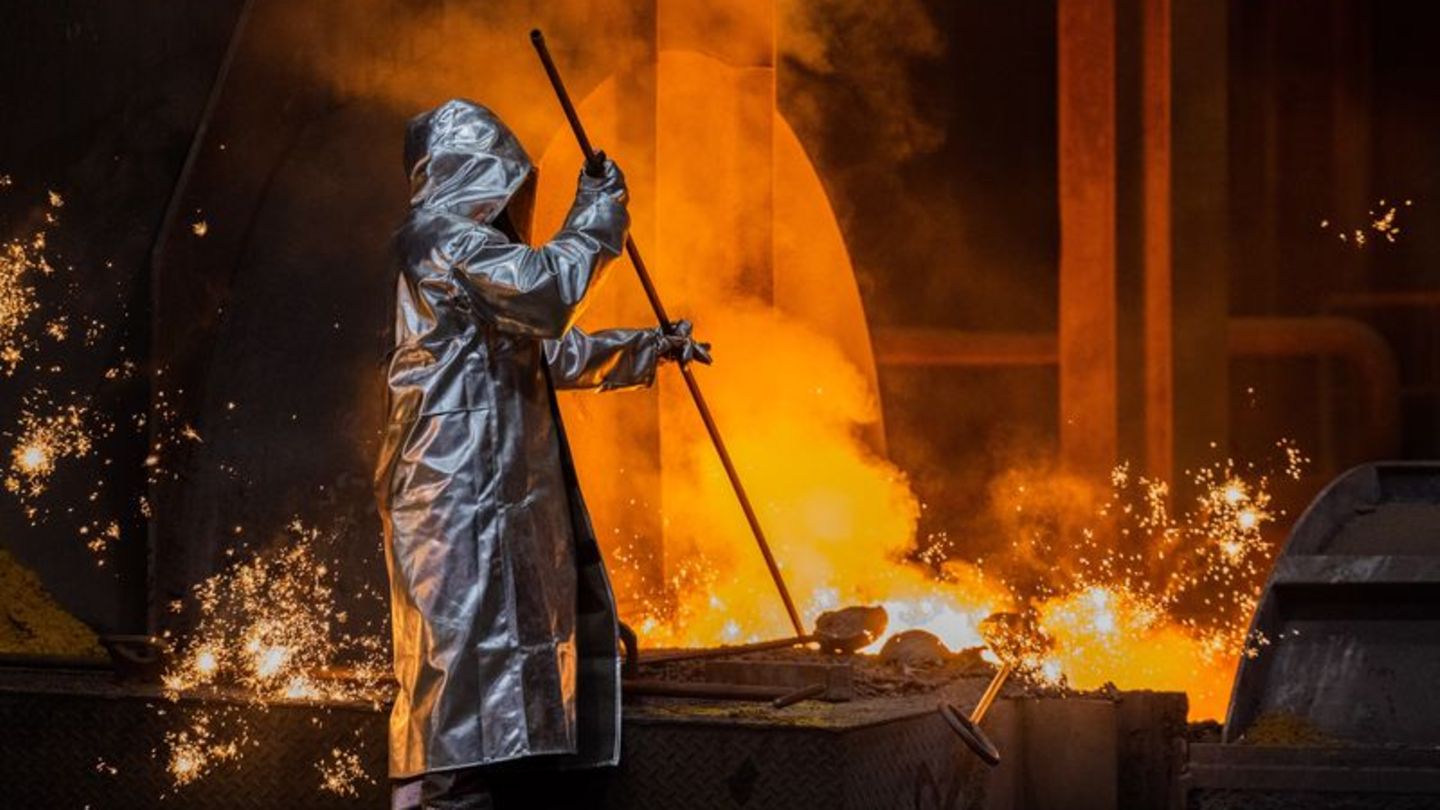 Ein Stahlarbeiter von Thyssenkrupp prüft den Roheisen am Hochofen 8 auf dem Werksgelände. Foto: Rolf Vennenbernd/dpa