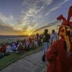 Thousands cheer the sun as it rises over Glastonbury and Stonehenge for summer solstice - just days after ancient monument was attacked by orange paint-wielding Just Stop Oil eco clowns