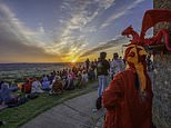 Thousands cheer the sun as it rises over Glastonbury and Stonehenge for summer solstice - just days after ancient monument was attacked by orange paint-wielding Just Stop Oil eco clowns