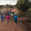Des coureurs kényans participent à une séance matinale du camp d'entraînement local à Iten, au Kenya, le 5 juin 2023. À près de 6 heures du matin, les premières lueurs du matin éclairent l'arche emblématique portant l'inscription "Home of Champions" à Iten.