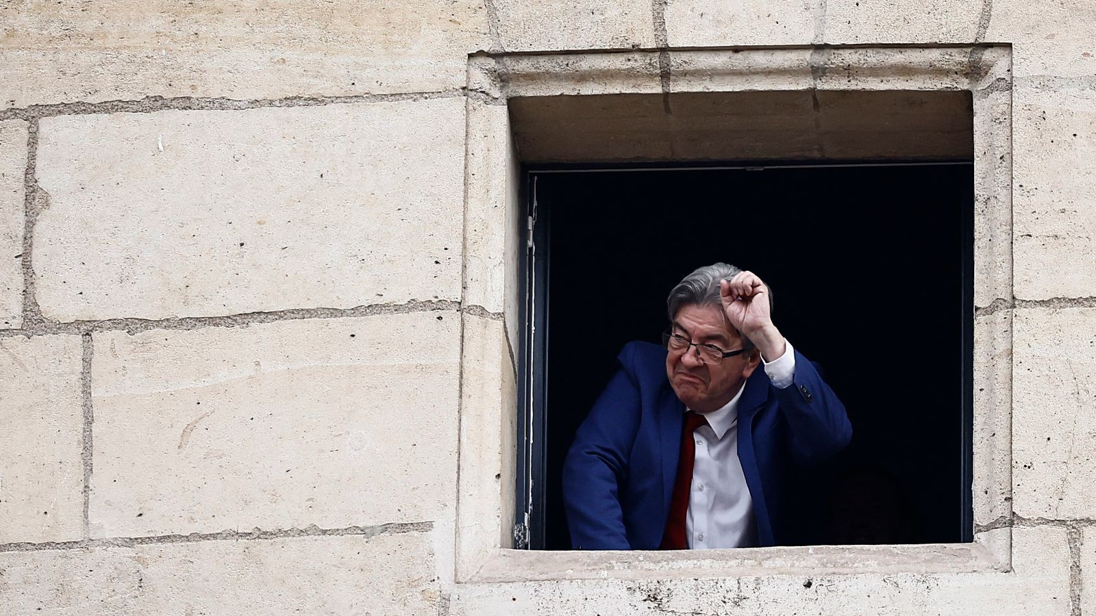 Jean-Luc Melenchon, leader of French far-left opposition party La France Insoumise (France Unbowed - LFI), and member of the alliance of left-wing parties, called the "Nouveau Front Populaire" (New Popular Front - NFP), gestures after partial results in the second round of the early French parliamentary elections, at Place Stalingrad in Paris, France, July 7, 2024. REUTERS/Yara Nardi