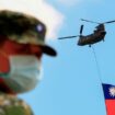 Des soldats taïwanais montent la garde alors qu'un hélicoptère Chinook portant un immense drapeau taïwanais survole un camp militaire, dans le cadre d'une répétition pour le survol de la célébration de la fête nationale du double dix de Taïwan, au milieu des tensions croissantes entre Pékin et Taipei et des menaces de la Chine à Taoyuan, Taïwan, le 28 septembre 2021.