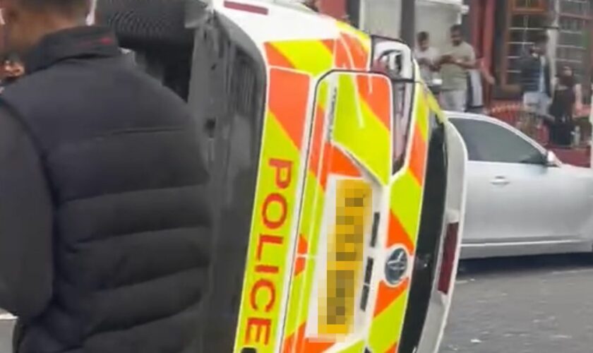 Police car flipped on to its side as unrest breaks out in Leeds