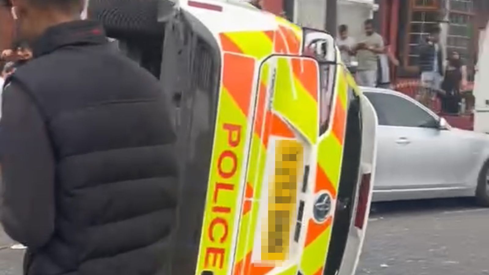 Police car flipped on to its side as unrest breaks out in Leeds