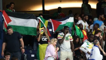 Als die israelische Hymne läuft, präsentieren Zuschauer ihre „Free Palestine“-Shirts
