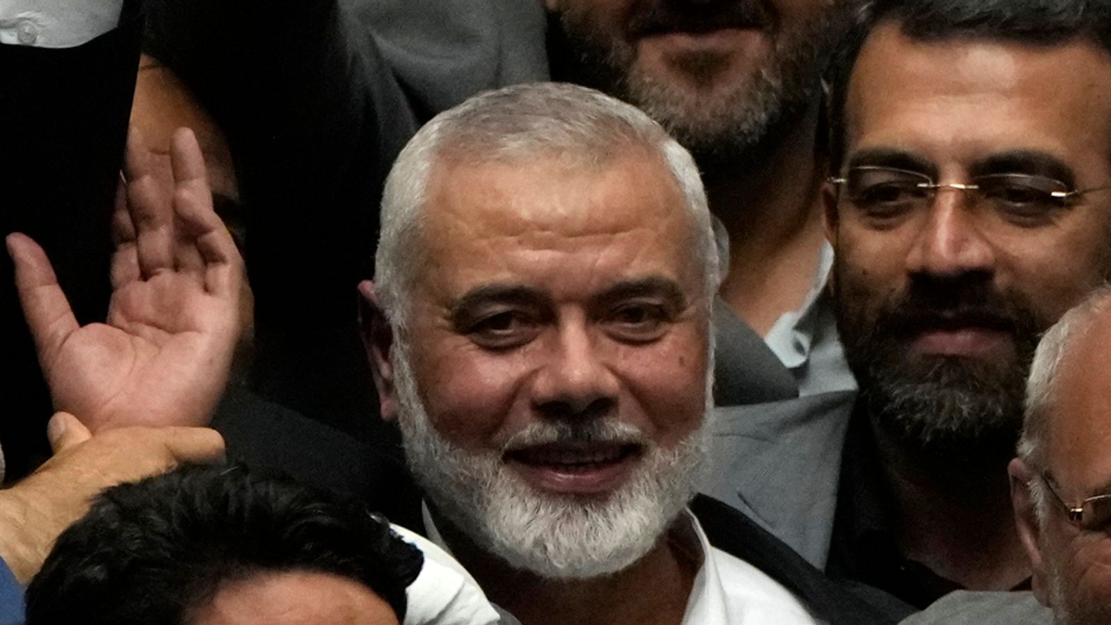 Haniyeh (centre) flashes a victory sign as he is surrounded by Iranian politicians. Pic: AP