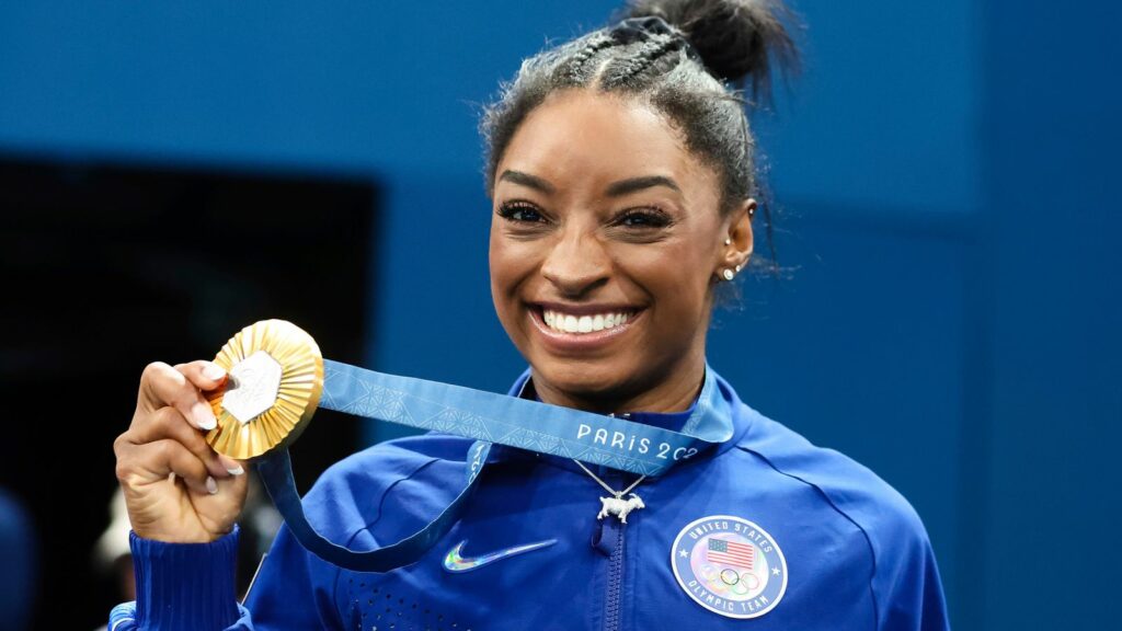 Simone Biles shows off her gold medal. Pic: Pete Dovgan/Speed Media/Icon Sportswire/AP