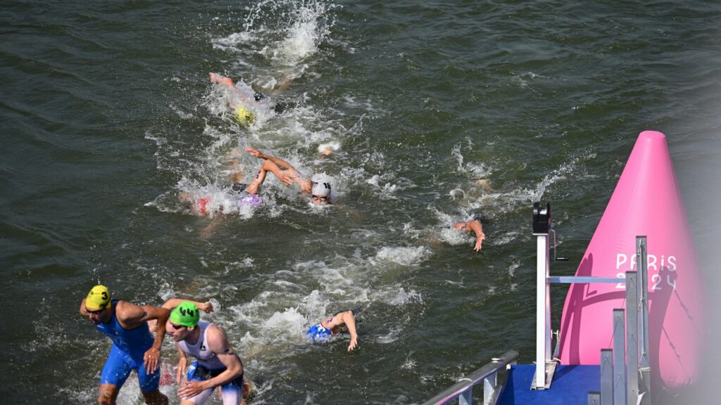 Athletes are swimming in the River Seine during the Men's Triathlon in Paris on July 31, 2024. The men's Olympic triathlon planned for the previous day has been postponed over concerns about water quality in the River Seine, where the swimming part of the race was scheduled to take place. ( The Yomiuri Shimbun via AP Images )