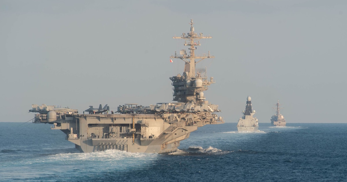 Le porte-avions USS Abraham Lincoln (G) passe le 19 novembre 2019 par le détroit d'Ormuz, dans le Golfe