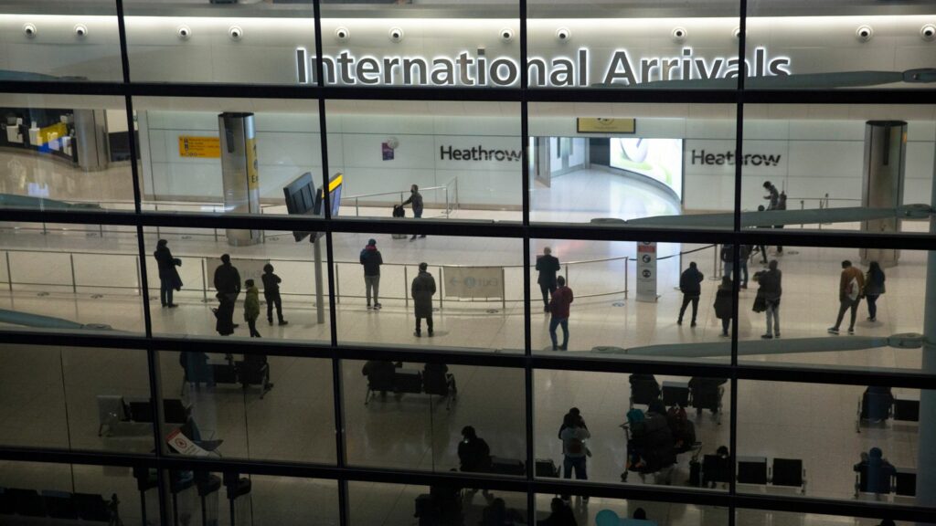 FILE - People in the arrivals area at Heathrow Airport in London, Jan. 26, 2021. The British government says it will grant extensions to several large U.K. airports unable to meet the June 1 deadline to fully install new scanning technology that would have allowed passengers to take two liters (70 ounces) of liquid in their hand luggage ... rather than the current paltry 100 milliliters (3.5 ounces). (AP Photo/Matt Dunham, File)