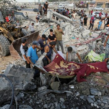 Palestinians at the site of an Israeli airstrike on a shelter in central Gaza on Saturday. Pic: Reuters