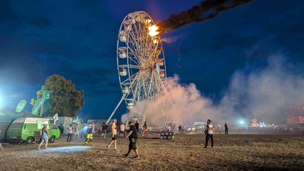 Festival-goers look on at the Ferris wheel fire. Pic: AP